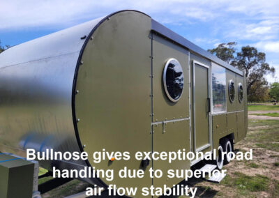 Olive green caravan featuring a bullnose front design, highlighting its aerodynamic shape for superior road handling and stability.