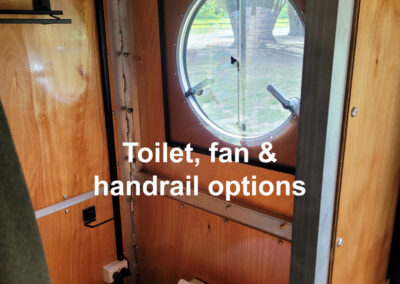Caravan bathroom showing a modern toilet with optional features like a fan for ventilation and a grab handrail for stability.
