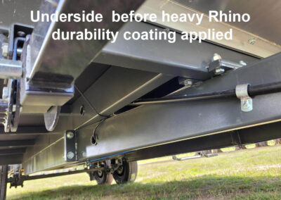 Underside of a caravan chassis before the application of a heavy-duty Rhino durability coating, showing the raw framework.