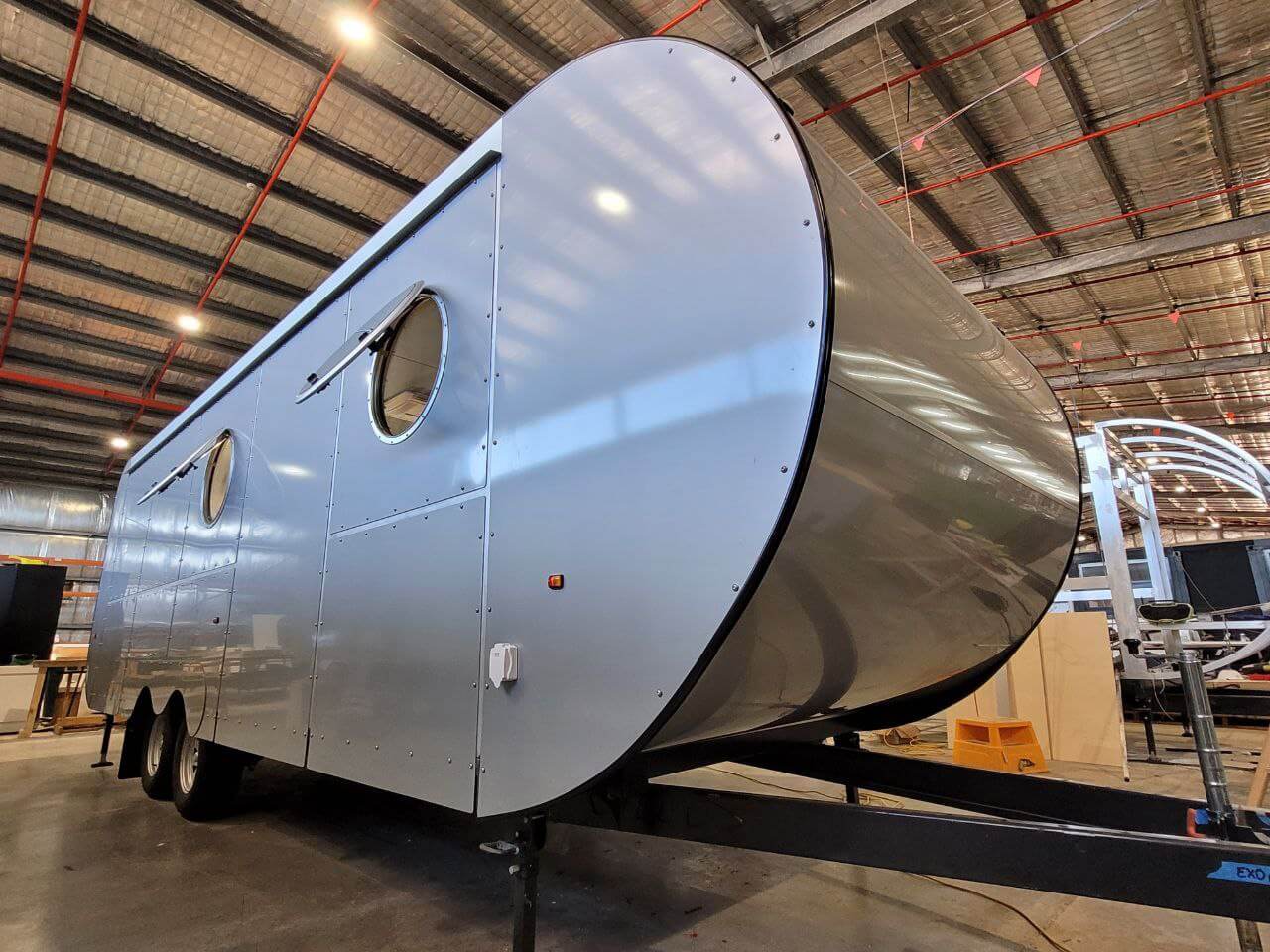 Silver caravan with a distinctive bullnose front design, emphasising aerodynamic shape for superior road handling and stability.