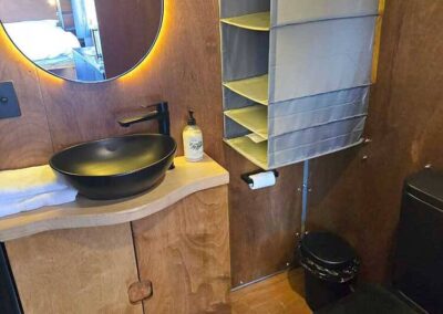 Caravan kitchen featuring a built-in microwave, white overhead cabinets, and a counter space, ready for appliances.