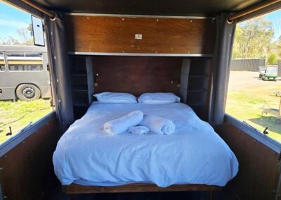 Caravan interior with a focus on a large, modern flat-screen TV mounted on the wall, integrated into the living area design.